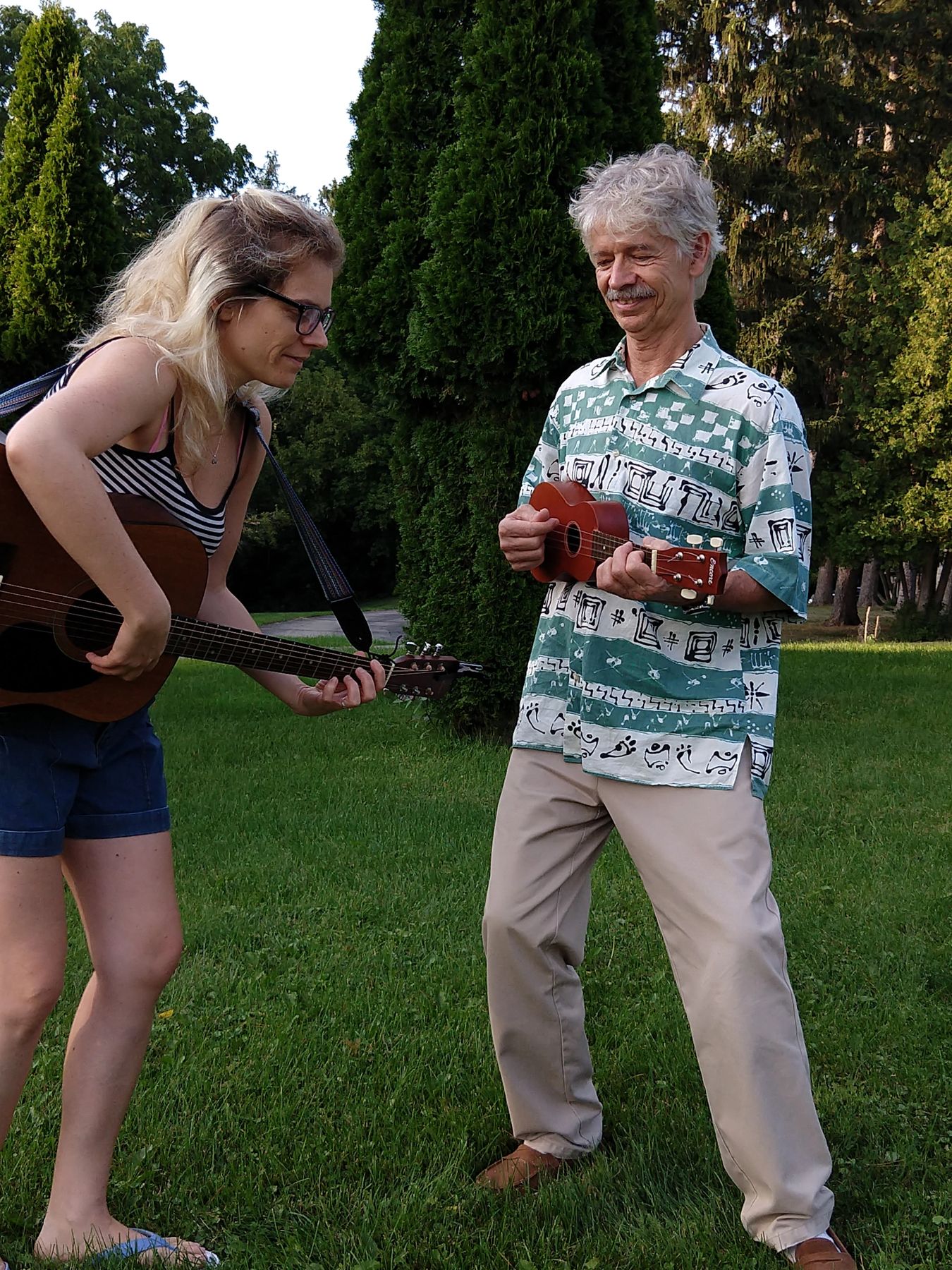 Zebie teaching ukulele to an adult student outdoors in Ann Arbor